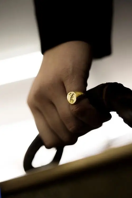 Anillo de sello en oro grabado, en la mano de un cliente